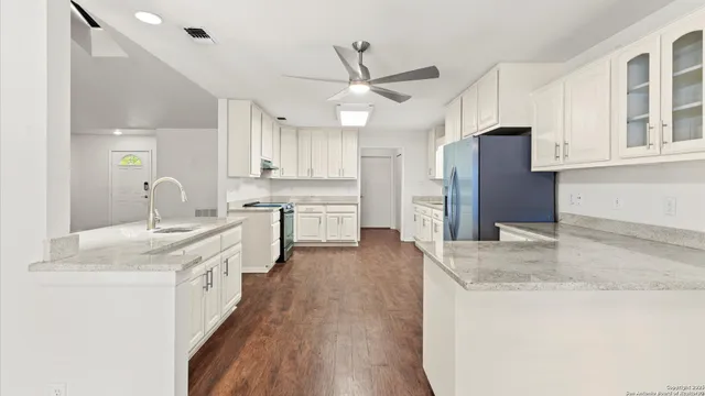 a kitchen with stainless steel appliances granite countertop a sink stove and refrigerator