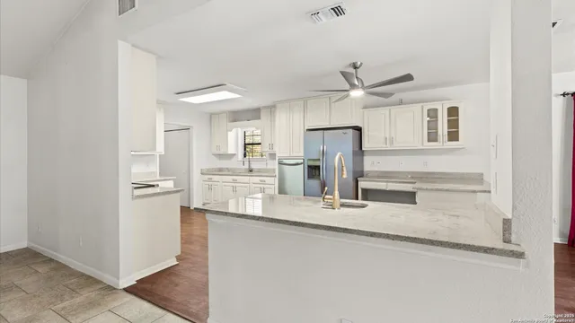 a kitchen with stainless steel appliances granite countertop a refrigerator and a sink