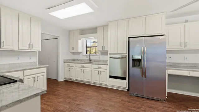 a kitchen with a refrigerator sink and cabinets