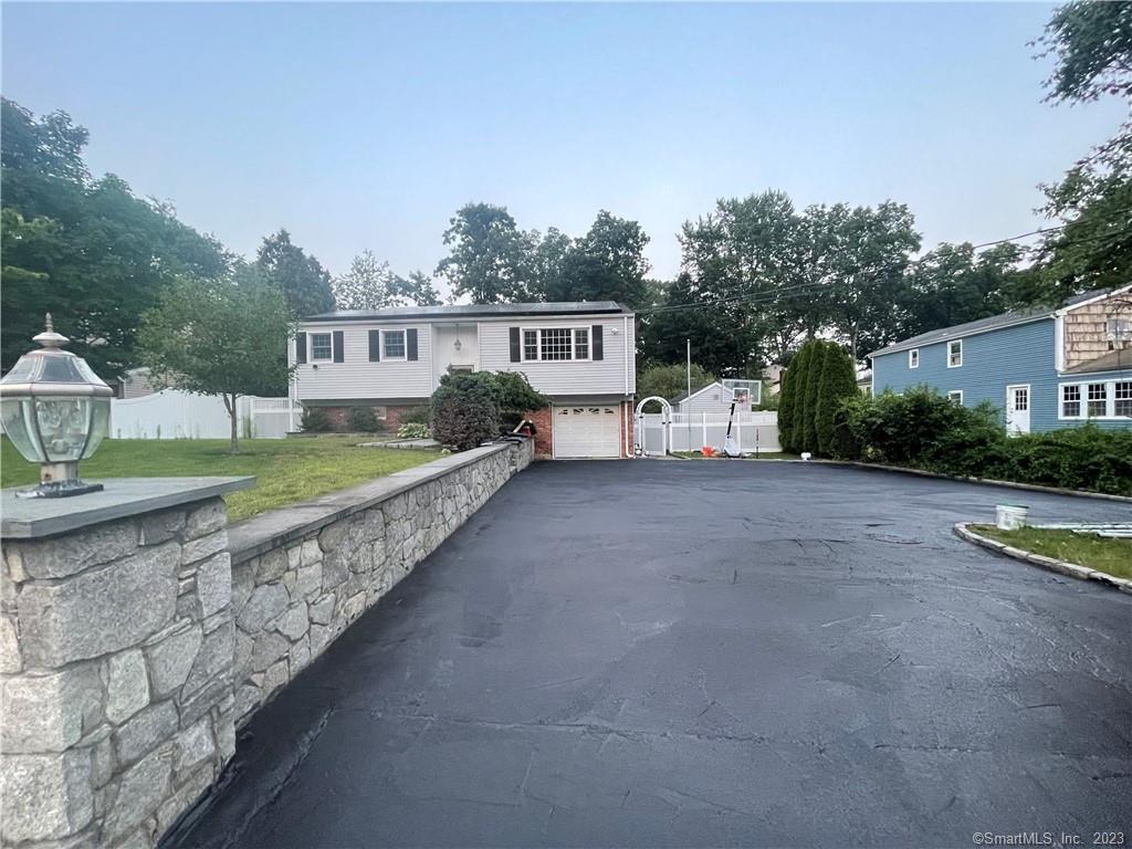 a view of a house with a yard and a large tree