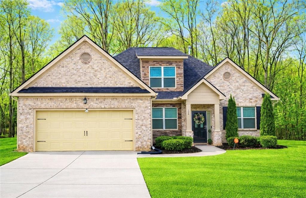 a front view of a house with a yard and garage