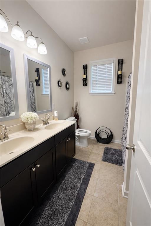 208 Sebastian Cove Hampton, GA 30228 - Photo 14 of 15 a bathroom with a double vanity sink a mirror and a toilet
