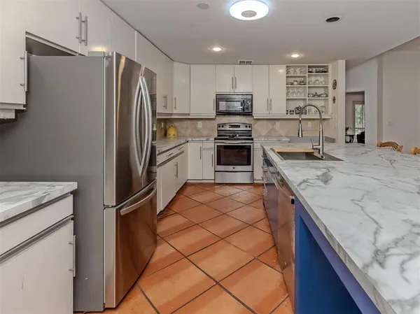a kitchen with granite countertop a refrigerator and a sink