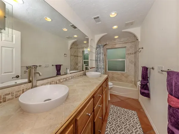 a bathroom with a double vanity sink a mirror and a bathtub