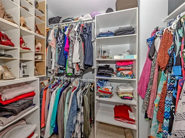 a view of walk in closet with clothes