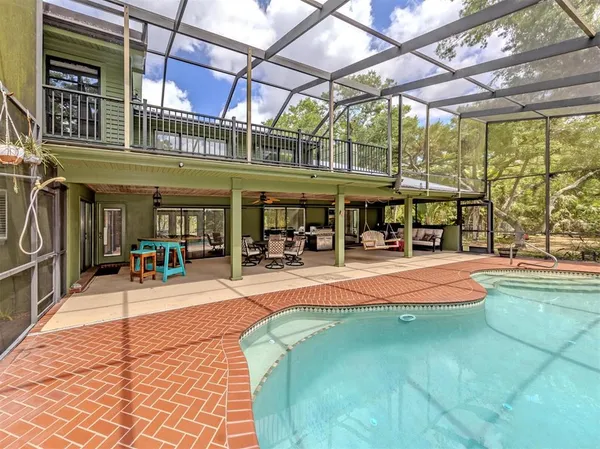 a view of a swimming pool with a patio and a backyard