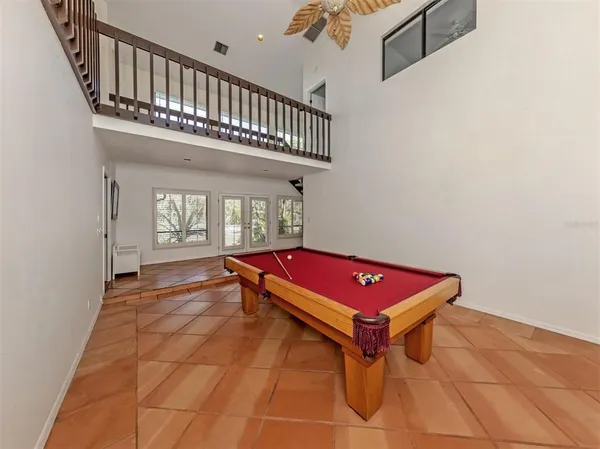 a room with pool table and windows