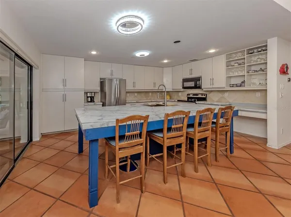 a kitchen with stainless steel appliances granite countertop a table and chairs in it