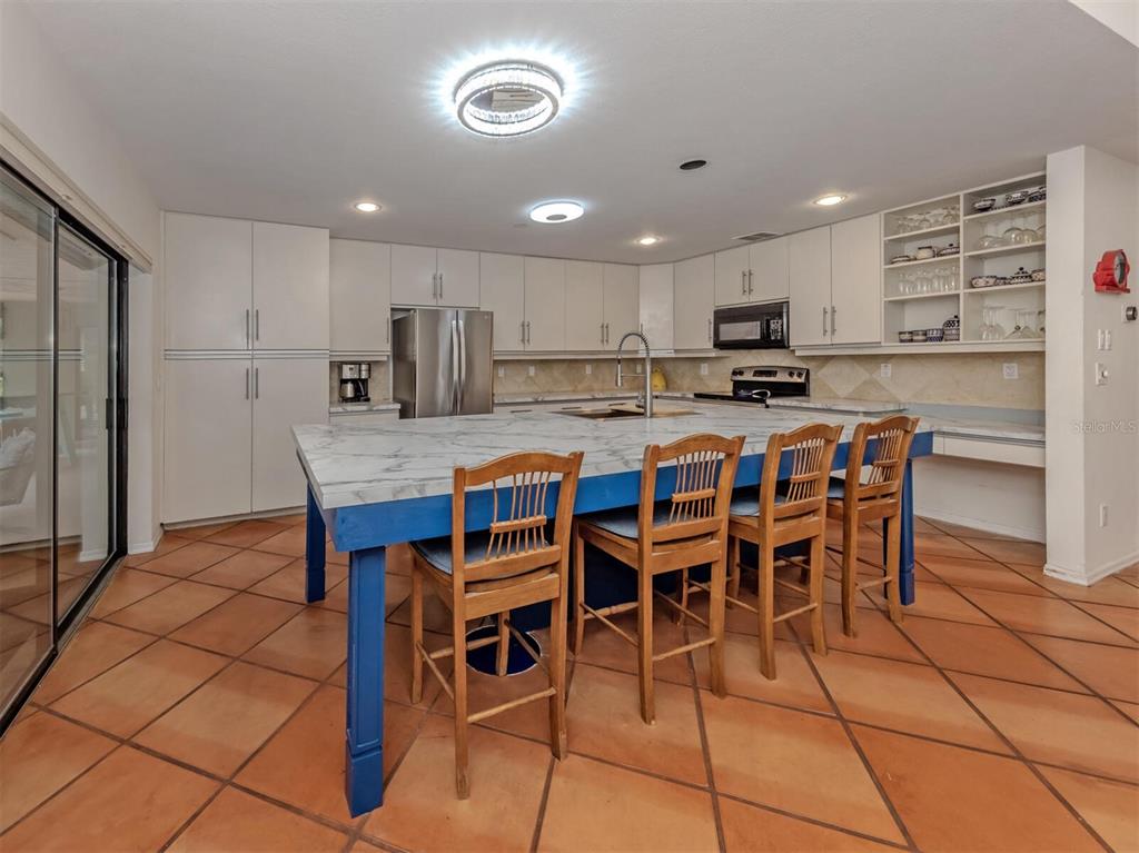 2602 Firetree Lane Venice, FL 34292 - Photo 10 of 31 a kitchen with stainless steel appliances granite countertop a table and chairs in it