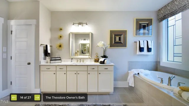 a bathroom with a tub a double vanity sink and a window