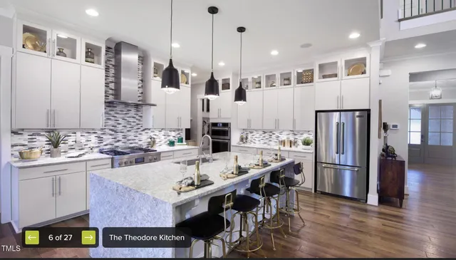 a kitchen with stainless steel appliances granite countertop a sink refrigerator and cabinets
