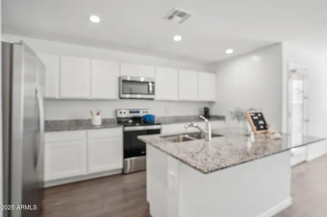 a kitchen with kitchen island granite countertop a stove sink and microwave