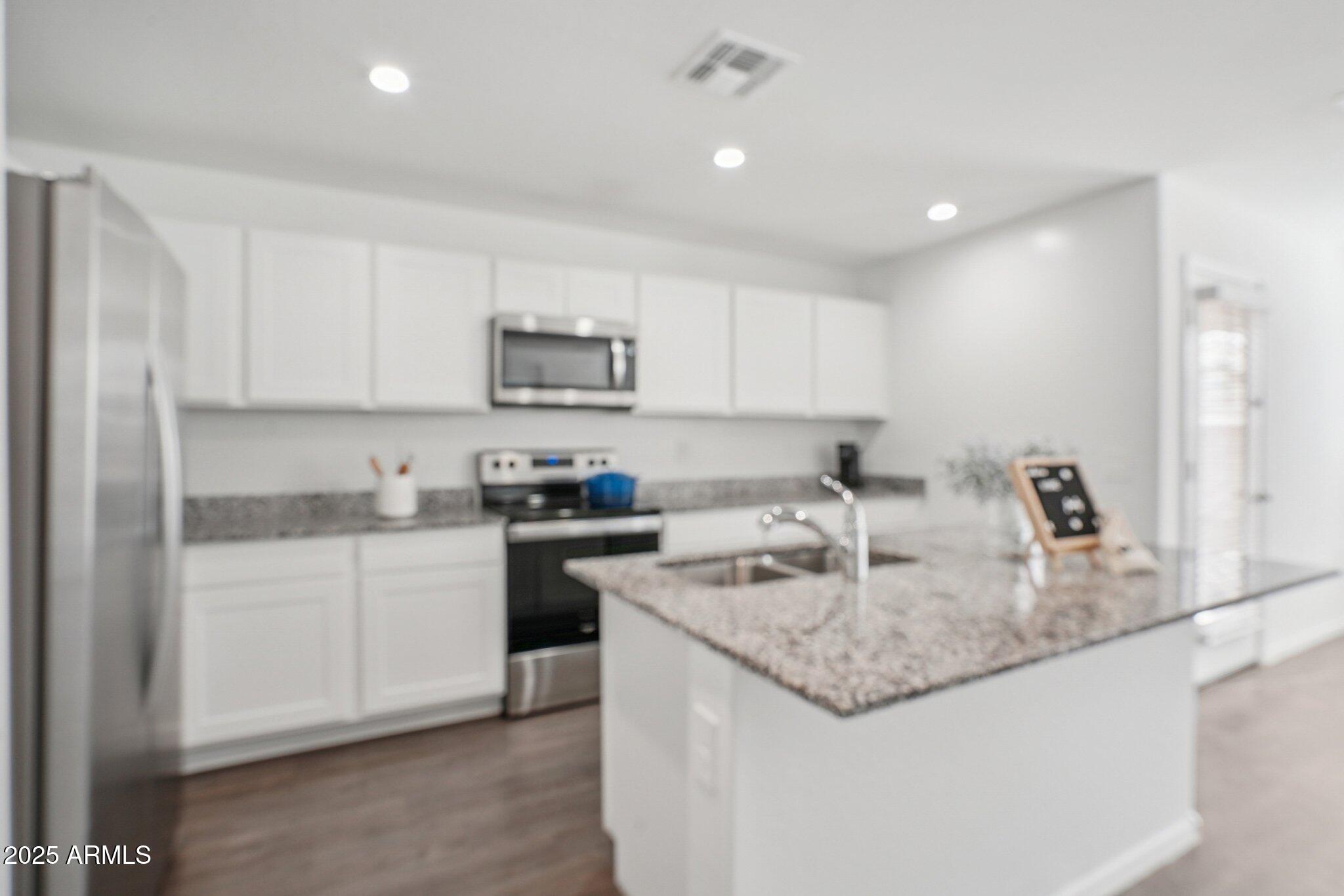 1566 East Yeoman Drive Casa Grande, AZ 85122 - Photo 12 of 28 a kitchen with kitchen island granite countertop a sink a stove and cabinets