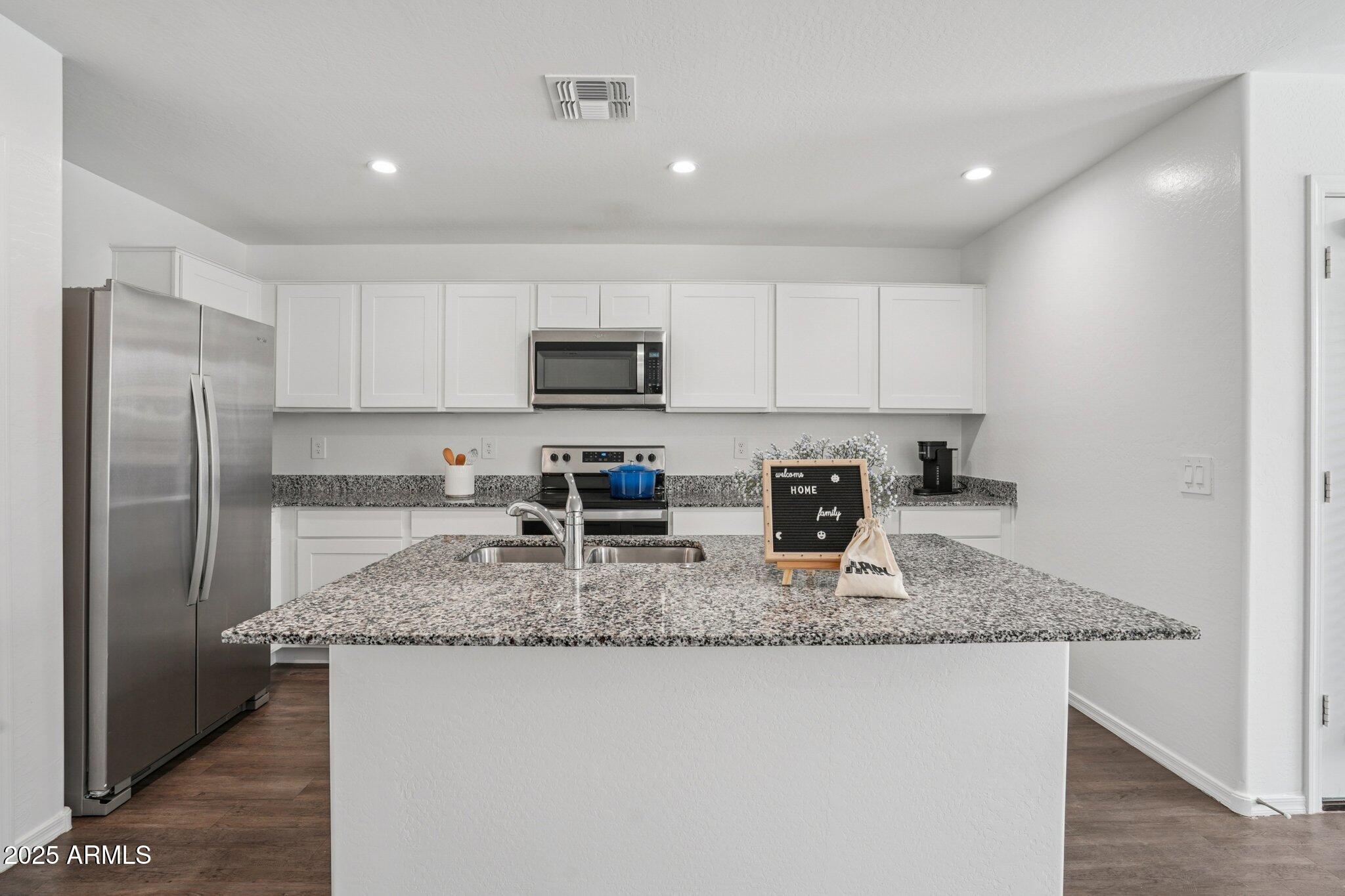 1566 East Yeoman Drive Casa Grande, AZ 85122 - Photo 13 of 28 a kitchen with kitchen island granite countertop a stove sink and microwave