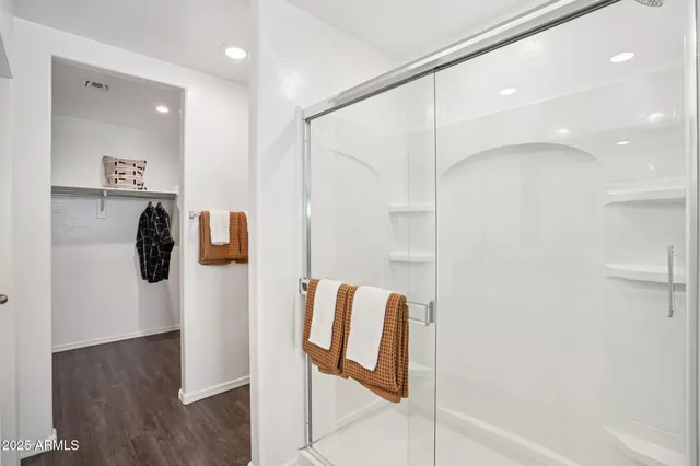 a view of walk in closet with clothes and shoes