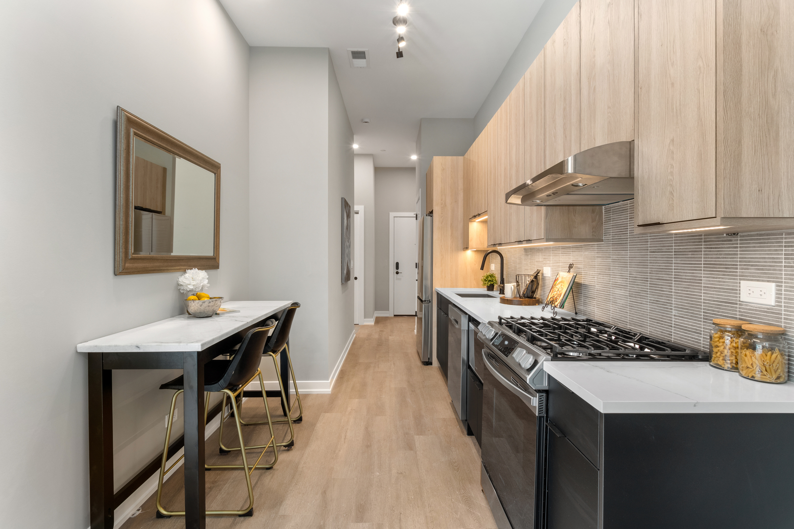 3217 North Clark Street, Unit 504 Chicago, IL 60657 - Photo 4 of 28 a kitchen with stainless steel appliances a stove a sink dishwasher and cabinets with wooden floor