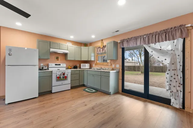 a kitchen with stainless steel appliances granite countertop a refrigerator a sink and a stove top oven