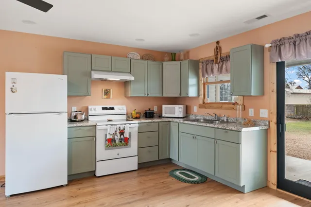 a kitchen with a stove top oven and refrigerator
