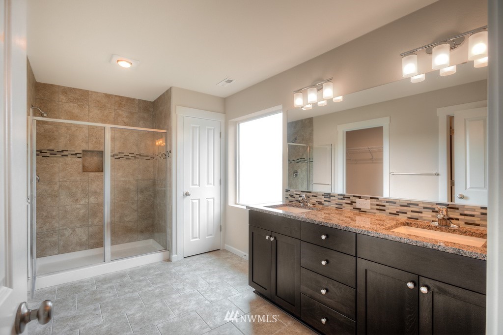 21118 Meridian Drive Southeast, Unit P4 Bothell, WA 98021 - Photo 12 of 29 a bathroom with a granite countertop sink a mirror and a shower