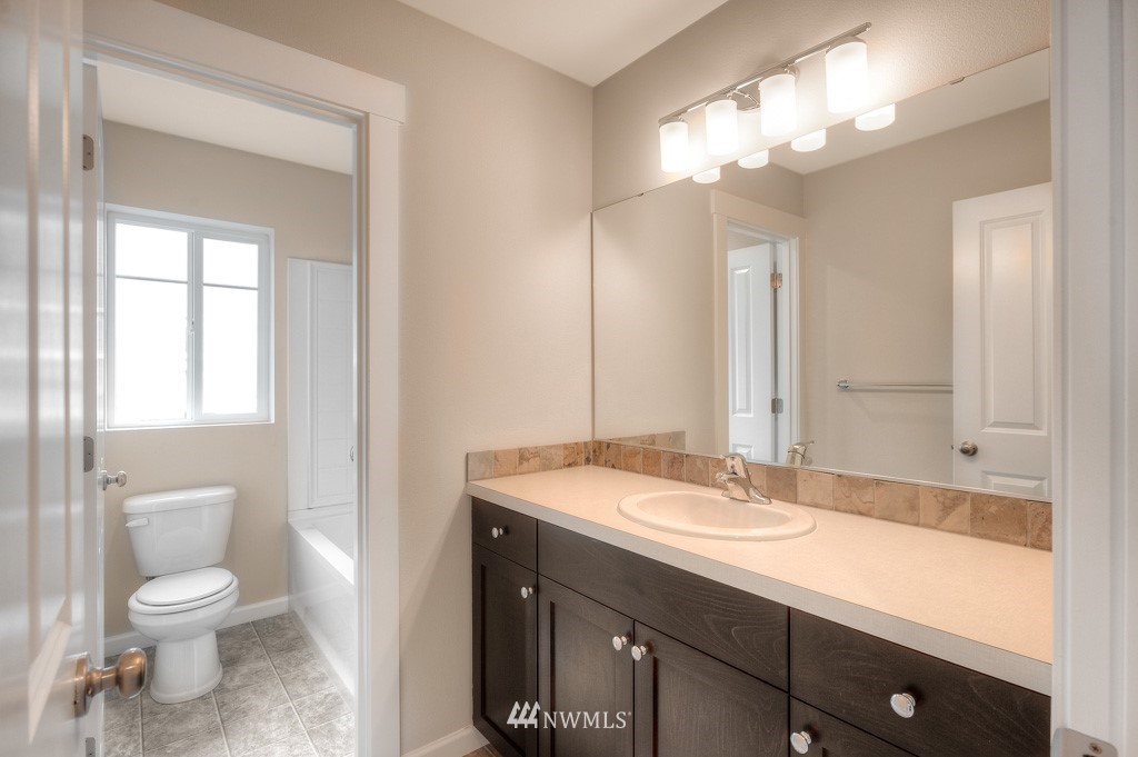21118 Meridian Drive Southeast, Unit P4 Bothell, WA 98021 - Photo 17 of 29 a bathroom with a sink a toilet and a large mirror