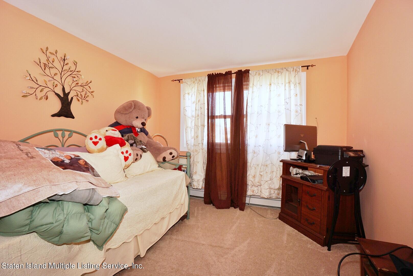 563 Mill Road Staten Island, NY 10306 - Photo 11 of 32 a bedroom with a bed and a computer on it