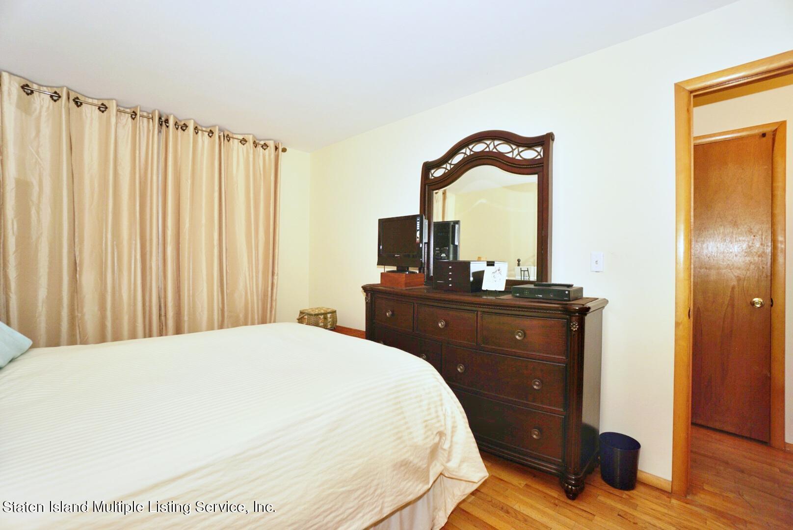 563 Mill Road Staten Island, NY 10306 - Photo 21 of 32 a bedroom with a bed and a dresser