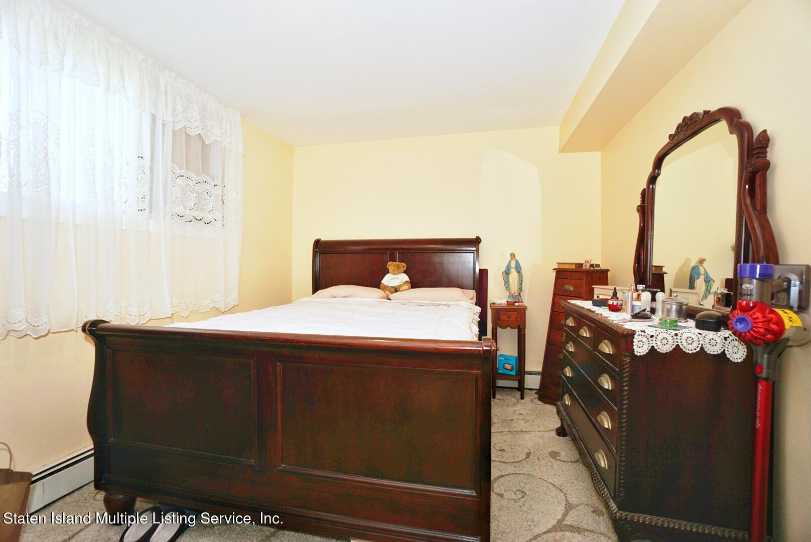 563 Mill Road Staten Island, NY 10306 - Photo 28 of 32 a bedroom with a bed and teddy bear on bed