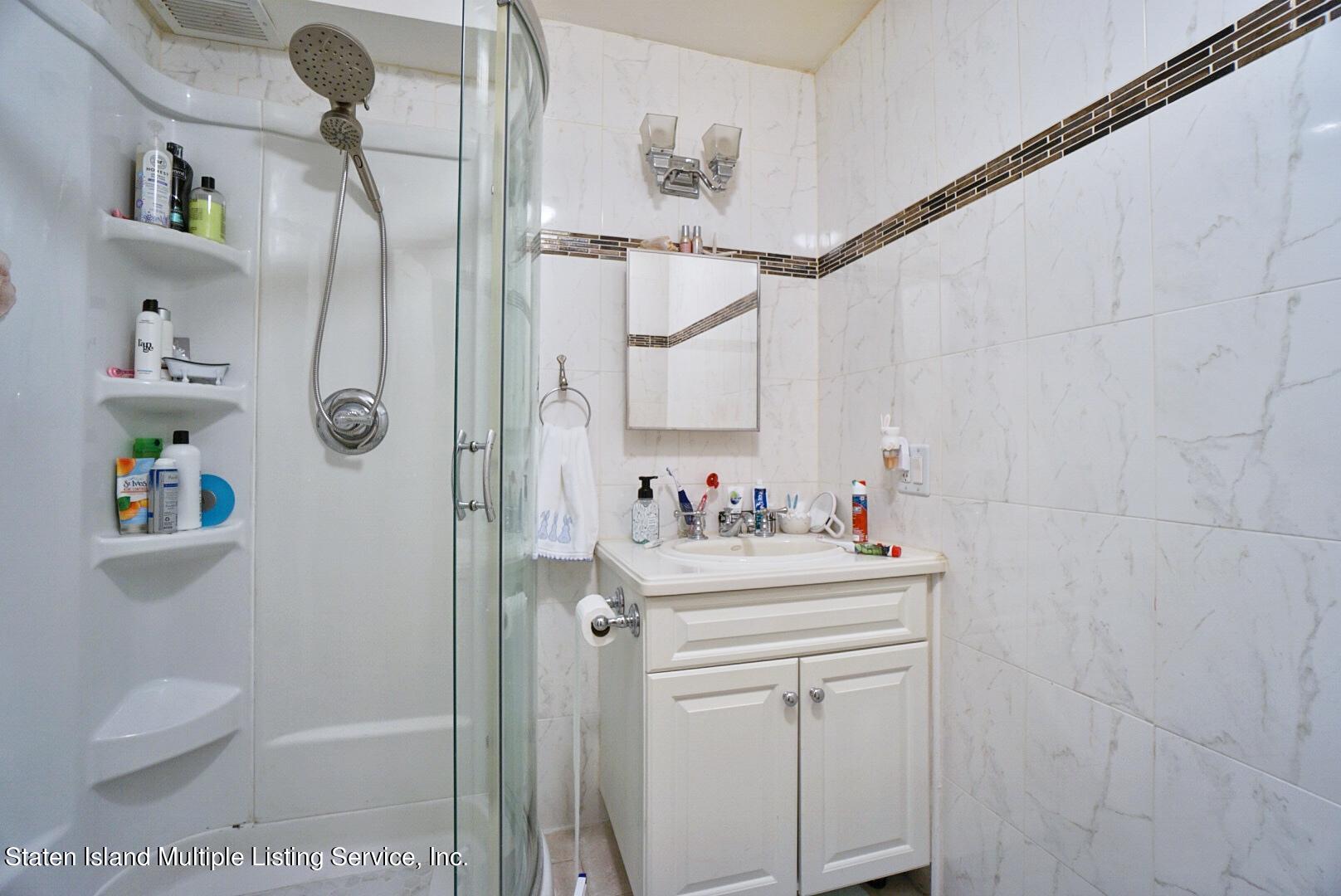 563 Mill Road Staten Island, NY 10306 - Photo 29 of 32 a bathroom with a sink a toilet and shower