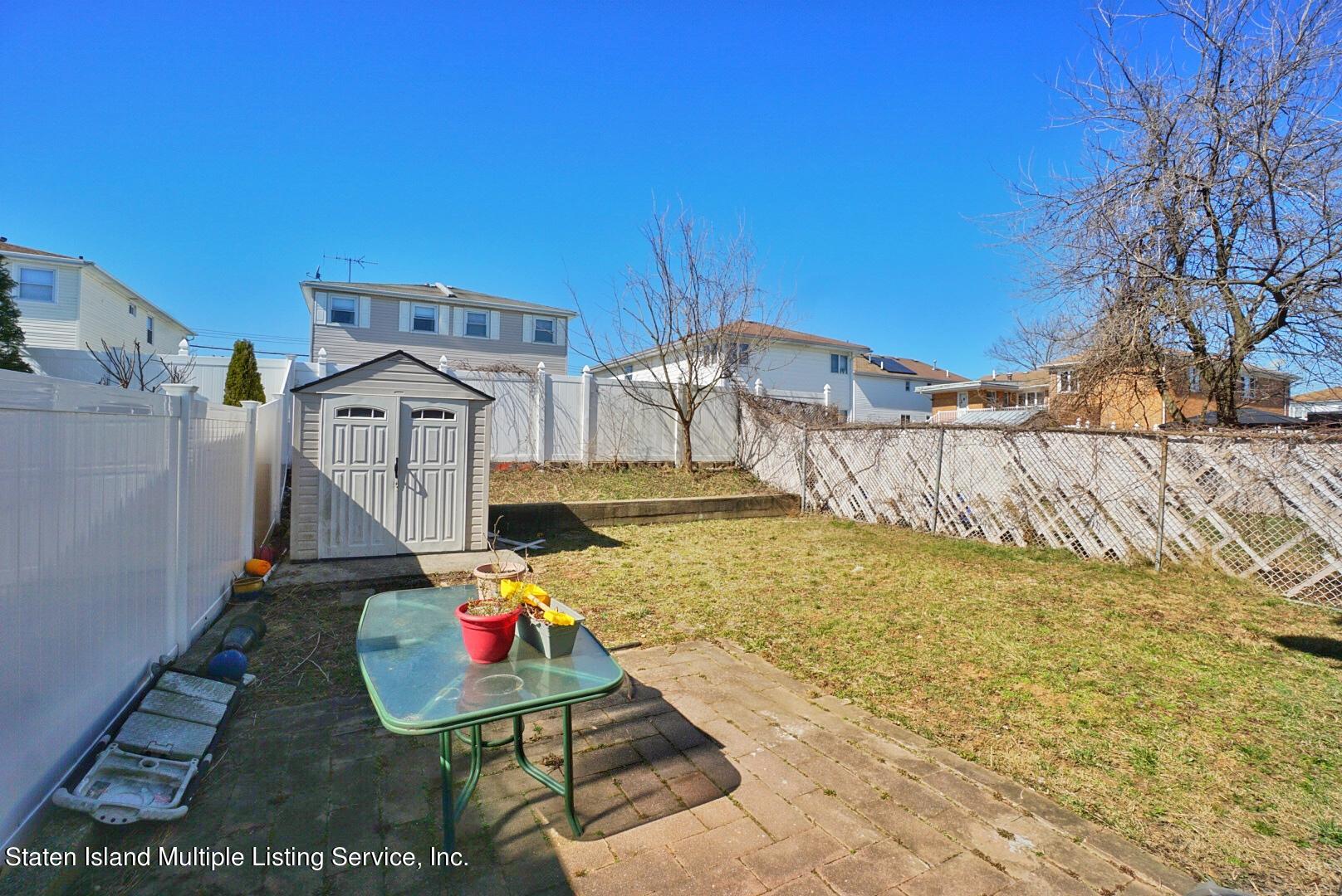 563 Mill Road Staten Island, NY 10306 - Photo 31 of 32 a backyard of a house with table and chairs