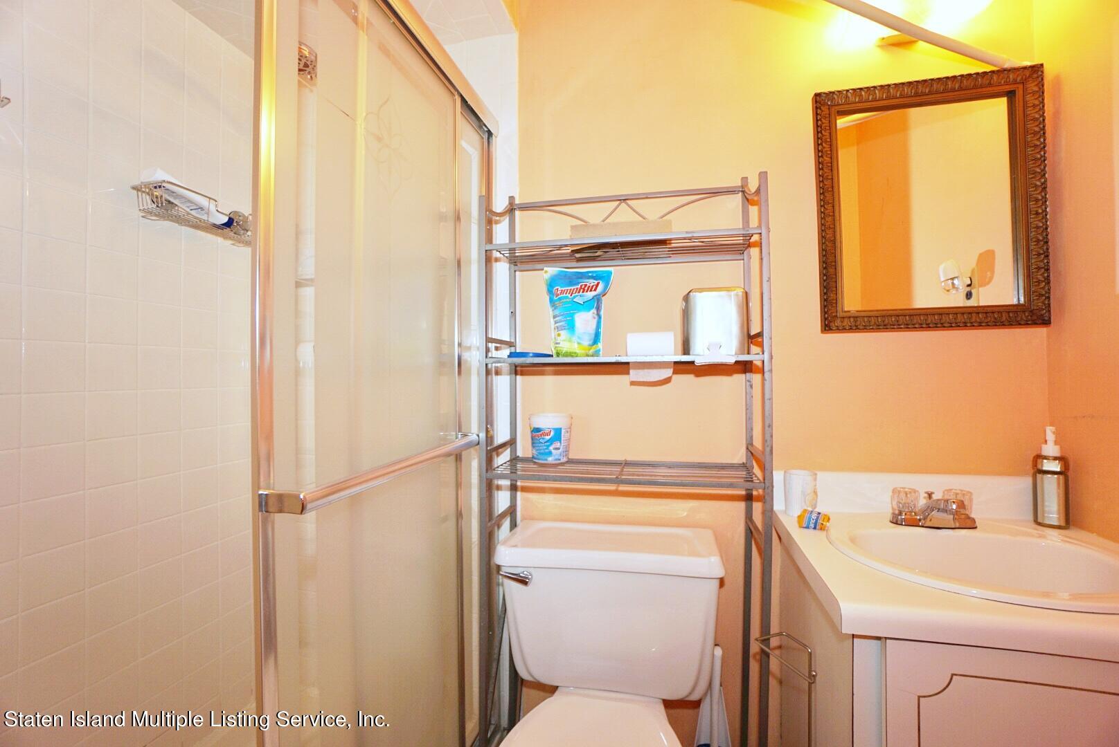 563 Mill Road Staten Island, NY 10306 - Photo 10 of 32 a bathroom with a toilet sink and mirror