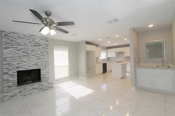 a view of a kitchen with a sink and a fireplace a window