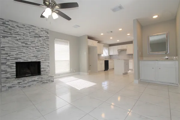 an empty room with windows and fireplace