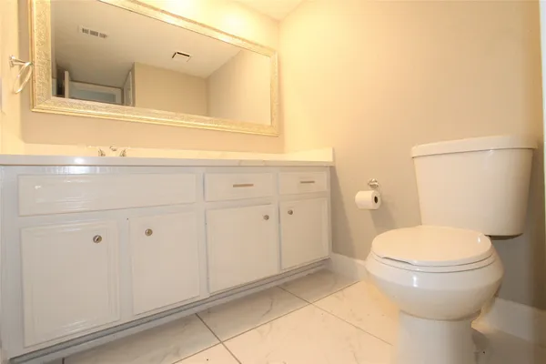 a bathroom with a sink mirror and a toilet