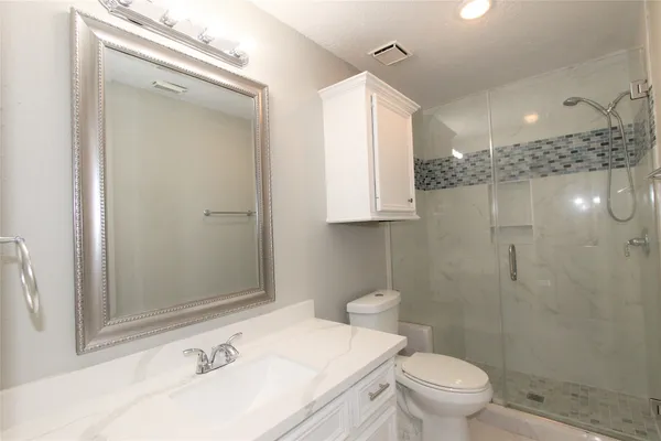 a bathroom with a sink a toilet and a mirror