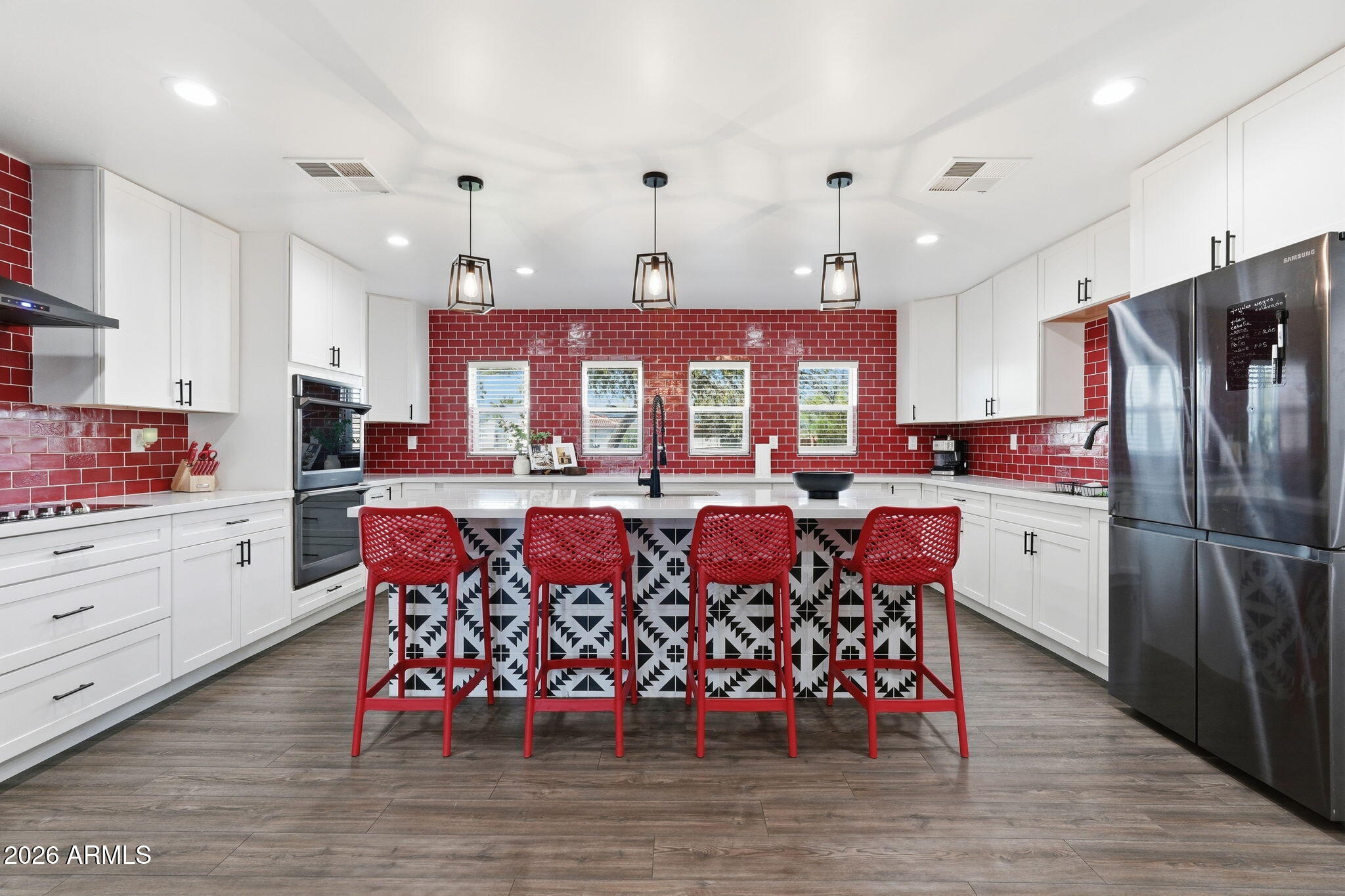 5009 East Wethersfield Road Scottsdale, AZ 85254 - Photo 21 of 30 a kitchen with stainless steel appliances a dining table chairs stove and cabinets