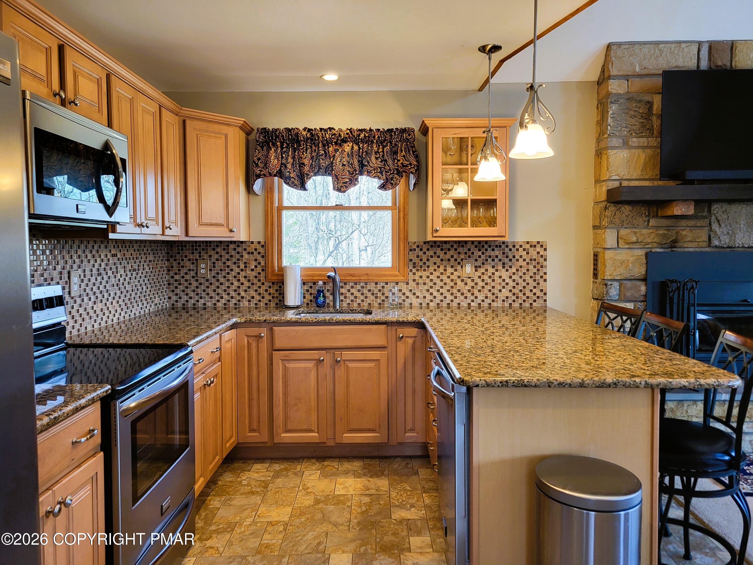 155 Clifton Drive Bushkill, PA 18324 - Photo 12 of 75 a kitchen with granite countertop a sink a stove and a microwave