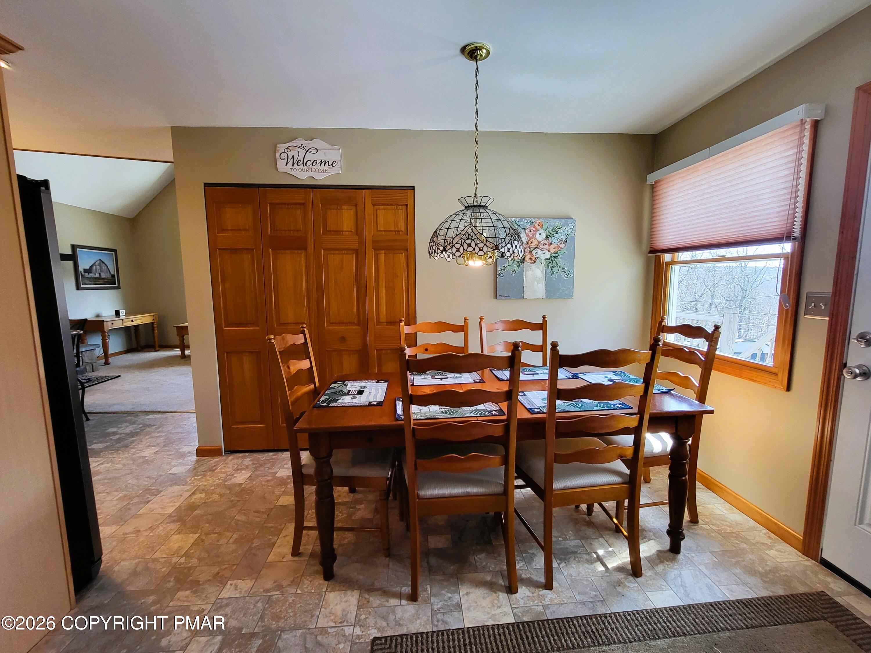 155 Clifton Drive Bushkill, PA 18324 - Photo 18 of 75 a view of a dining room with furniture wooden floor and a chandelier