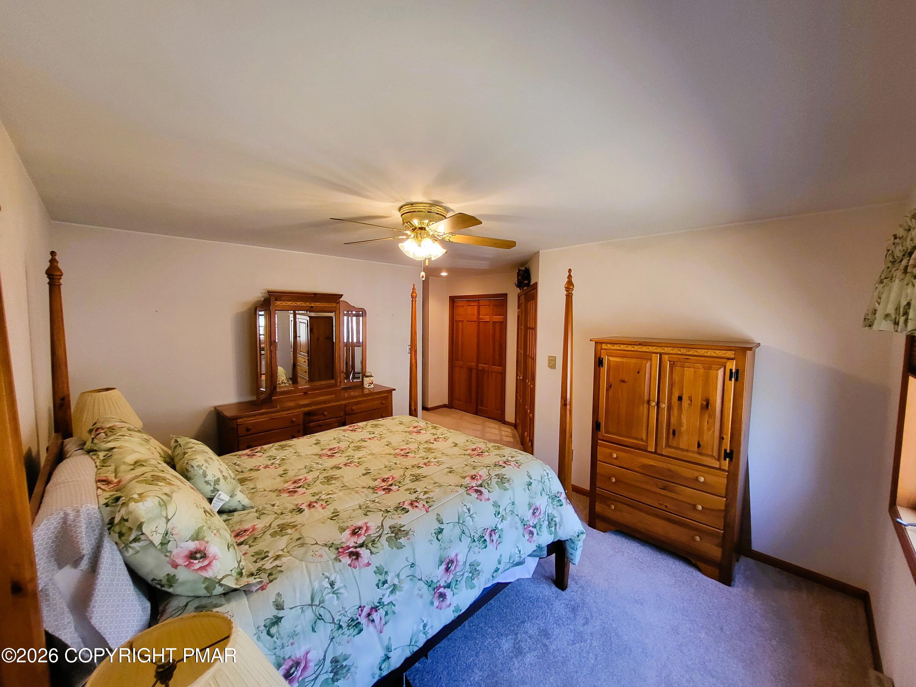155 Clifton Drive Bushkill, PA 18324 - Photo 28 of 75 a bedroom with a bed and a chandelier