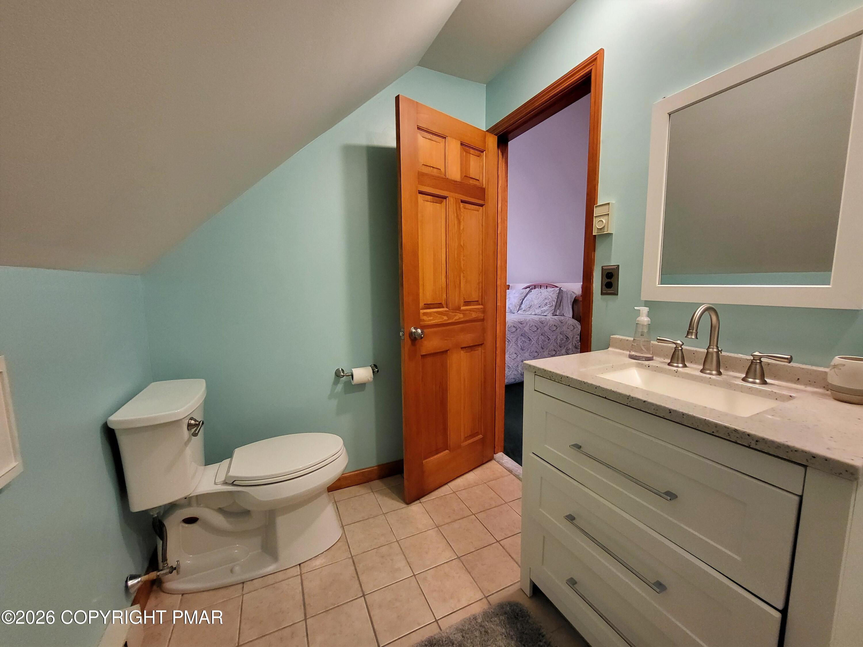 155 Clifton Drive Bushkill, PA 18324 - Photo 40 of 75 a bathroom with a granite countertop toilet a sink and a mirror