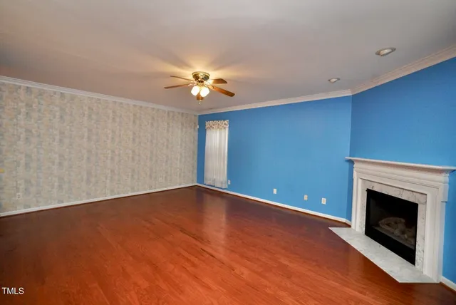 a view of an empty room with a fireplace and a window