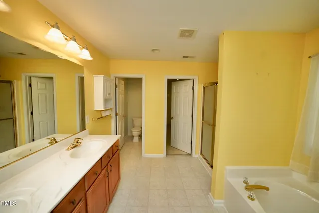 a spacious bathroom with a double vanity sink and a mirror