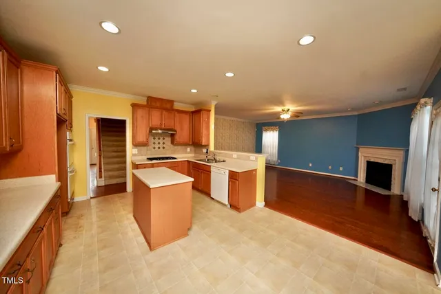 a large kitchen with stainless steel appliances kitchen island a large counter top a stove and a refrigerator
