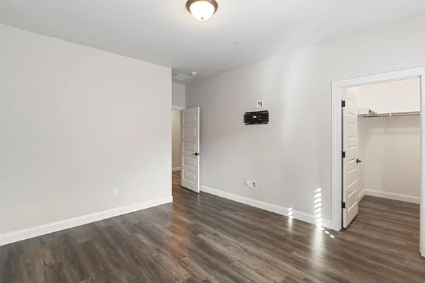 an empty room with wooden floor and windows