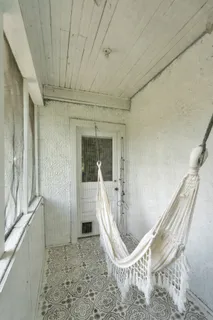 a porch with a chair and potted plant
