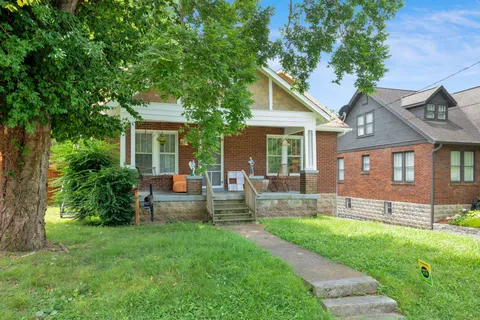 a front view of a house with a yard and green space