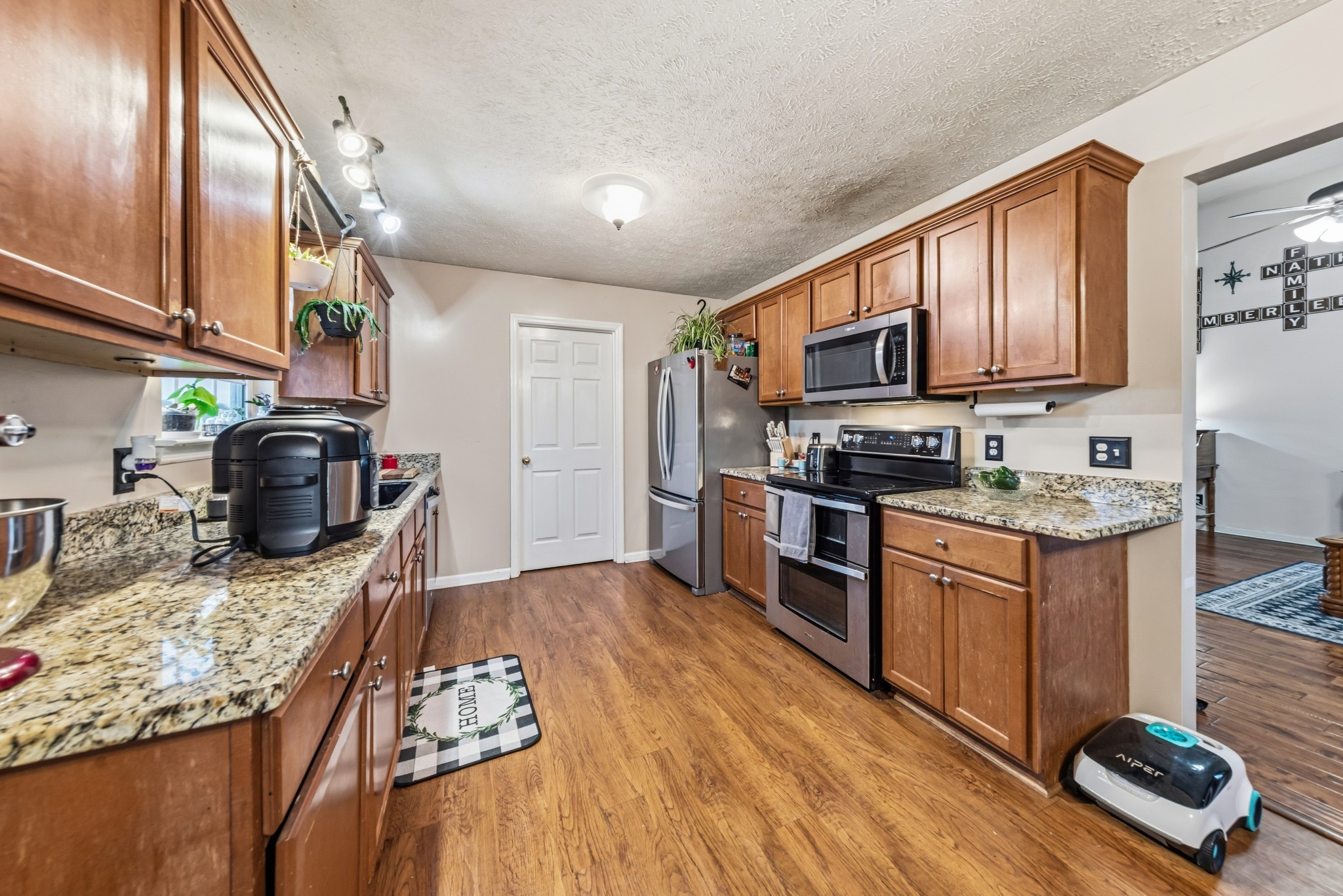 699 Puckett Road Watertown, TN 37184 - Photo 20 of 53 a kitchen with granite countertop a stove top oven a sink dishwasher a dining table and chairs with wooden floor
