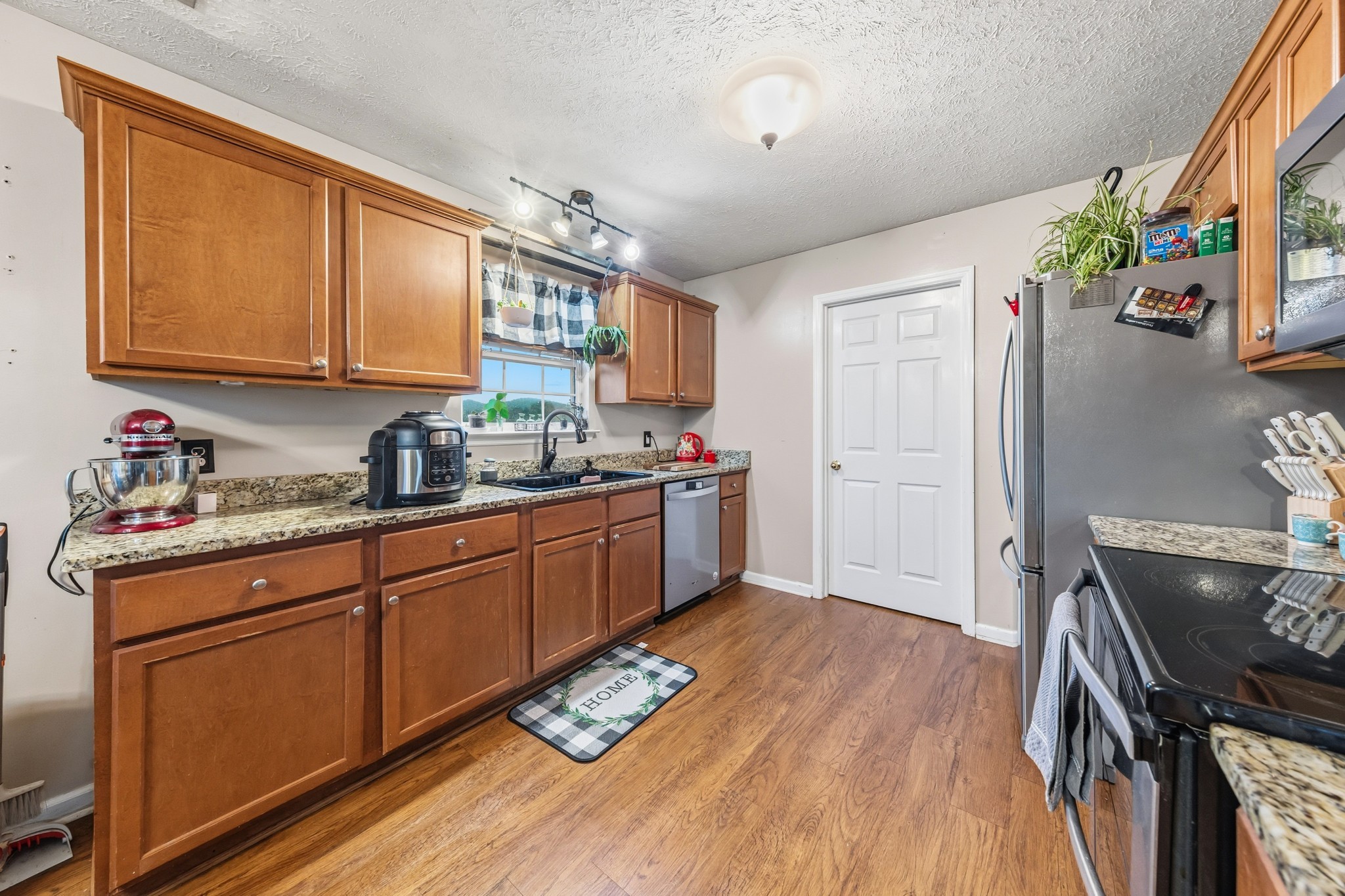 699 Puckett Road Watertown, TN 37184 - Photo 21 of 53 a kitchen with stainless steel appliances granite countertop a sink stove and wooden floor