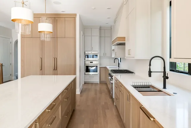 a kitchen with kitchen island a counter top space a sink stainless steel appliances and cabinets