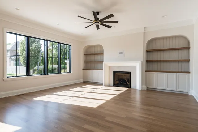 a view of an empty room with a fireplace and a window