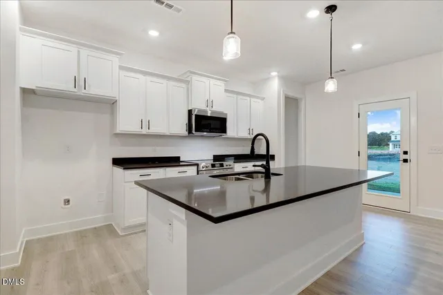 a kitchen with stainless steel appliances granite countertop a sink and a stove top oven